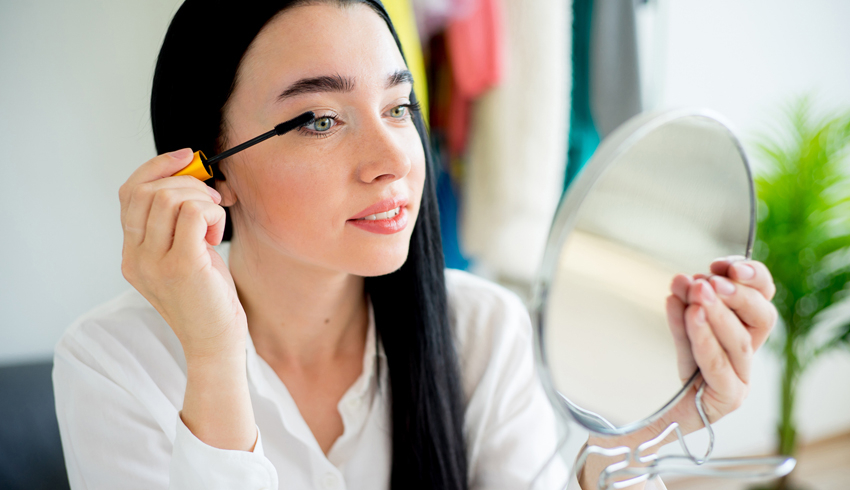 a woman applying mascara